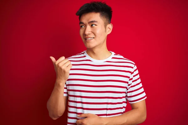 Zole Kırmızı Arka Plan Üzerinde Duran Çizgili Shirt Giyen Genç — Stok fotoğraf