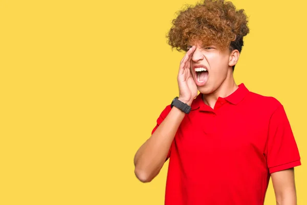 赤いTシャツを着たアフロヘアの若いハンサムな男が叫び 口に手を当てて大声で叫ぶ コミュニケーションコンセプト — ストック写真