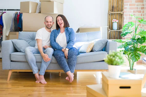 Junges Paar Sitzt Auf Dem Sofa Inmitten Von Pappkartons Die — Stockfoto