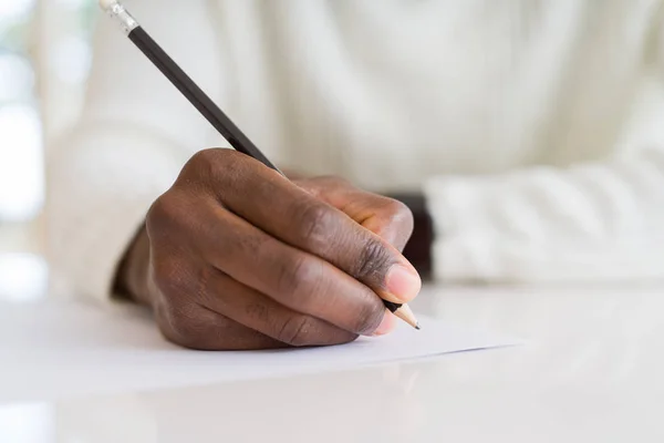 Close Van Afrikaanse Man Het Schrijven Van Een Briefje Een — Stockfoto