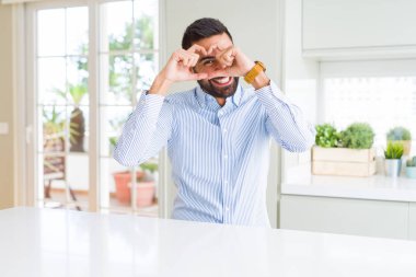 Yakışıklı İspanyol iş adamı el ve parmaklarla kalp şekli yapmak burcuna bakarak gülümseyerek