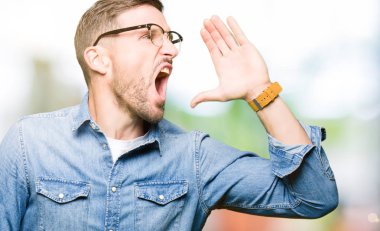 Bağırarak ve ağzı üzerinde el ile yan için çığlık gözlük takan yakışıklı adam. İletişim kavramı.