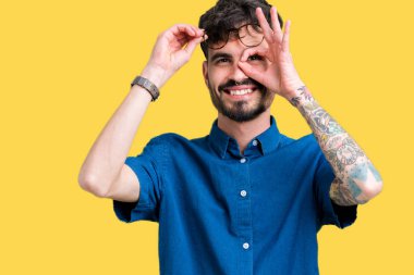 Gülümseyen, parmakları ile mutlu yüz üzerinden seyir göz el ile ok jest yapıyor izole arka plan üzerinde gözlük takan genç yakışıklı adam.