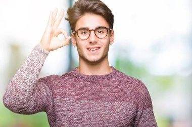 İzole arka plan el ve parmaklar ok işaretiyle yapıyor olumlu gülümseyen üzerinde gözlük takan yakışıklı delikanlı. Başarılı ifade.
