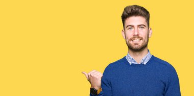 Genç yakışıklı Bussines adam mutlu yüz görünümlü ve başparmak yukarı ile yan işaret gülümseyen.