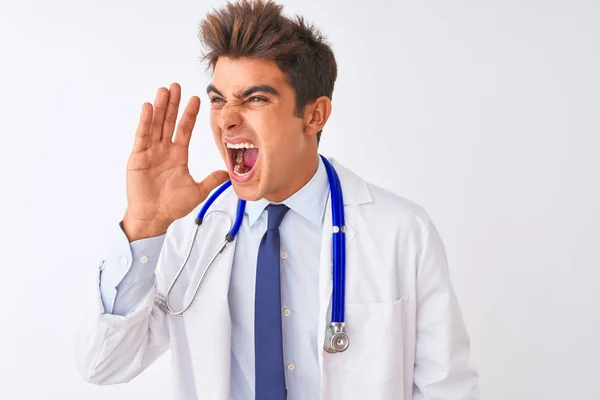 Młody Przystojny Lekarz Człowiek Sobie Stetoskop Białym Tle Krzycząc Krzyczeć — Zdjęcie stockowe