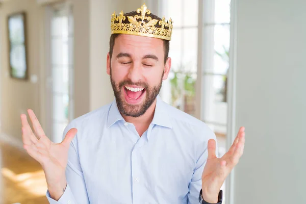 英俊的商人戴着金冠作为国王或王子庆祝疯狂和疯狂的成功与手臂抬起和闭上眼睛尖叫兴奋 优胜者概念 — 图库照片
