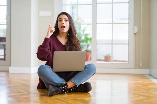 年轻女子用电脑笔记本电脑坐在地板上指着手指 提出成功的想法 退出和快乐 — 图库照片