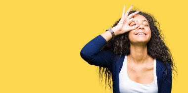 Gülümseyen, parmakları ile mutlu yüz üzerinden seyir göz el ile ok jest yapıyor kıvırcık saçlı Genç güzel kız.