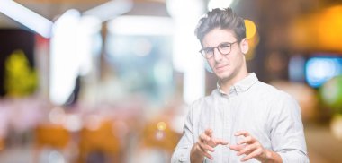 Yakışıklı delikanlı izole arka plan üzerinde gözlük tiksinti ifadesi, memnun ve korkulu tiksinti yüz yapıyorsun çünkü nefret tepki. Elleriyle kaldırdı. Sinir bozucu kavramı.