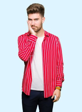 Kırmızı gömlek düşünme seyir giyen genç yakışıklı adam yorgun ve sıkılmış çapraz silah depresyon sorunları ile.