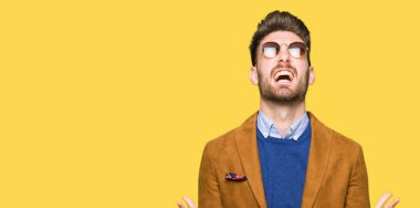 Genç yakışıklı zarif adam çılgın ve kızgın bağırarak ve agresif ifade ve silah kaldırdı bağırmaya güneş gözlüğü takıyor. Hayal kırıklığı kavramı.