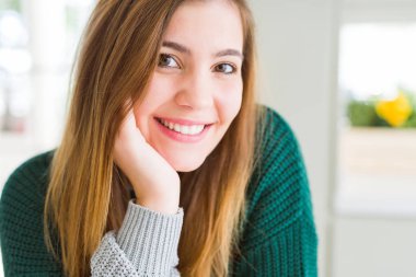 Kameraya emin gülümseyen güzel genç kadın