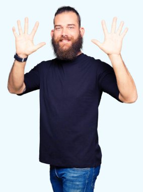 Gösterilen ve parmakları ile işaret rahat t-shirt giyen genç sarışın adam kendinden emin ve mutlu gülümseyerek süre on numara.
