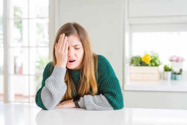 Genç güzel artı boyutu kadın rahat çizgili kazak giyen yaslama yorgun yarım yüz kapsayan, göz ve el ile ağız. Yüz acı içinde acıyor.