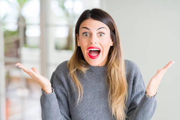 Jovem Mulher Bonita Vestindo Camisola Inverno Casa Celebrando Louco Espantado — Fotografia de Stock