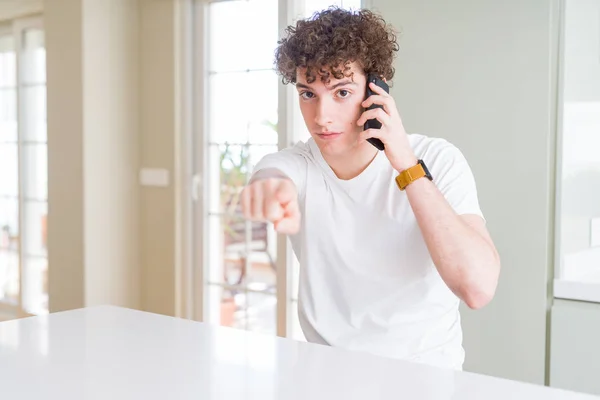 Joven Hablando Por Teléfono Casa Señalando Con Dedo Cámara Signo — Foto de Stock