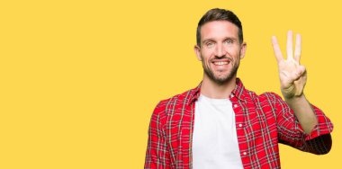 Yakışıklı adam kadar rahat gömlek gösterme ve işaret parmakları ile giyen üç kendinden emin ve mutlu gülümseyerek iken numara.