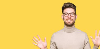 Gösterilen ve parmak sayısı on kendinden emin ve mutlu gülümseyerek süre ile yukarıyı gözlüklü genç yakışıklı iş adamı.