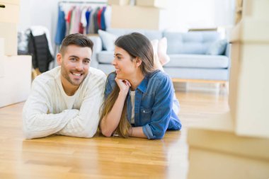 Yeni evin katında yatan genç güzel çift, yeni daireye taşınmak için çok mutlu aşk gülümsüyor