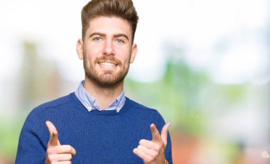 Genç yakışıklı bussines adam kameraya mutlu ve komik suratla parmakları işaret. İyi enerji ve vibes.