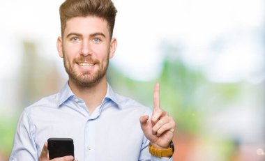 Akıllı telefon kullanarak genç yakışıklı adam iş bir fikir veya soru mutlu yüz, bir numara ile parmak işaret ile şaşırttı