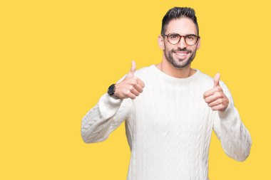 Yakışıklı delikanlı izole arka plan başarı işareti el ile pozitif jest yapıyor üzerinde gözlük takan başparmak gülümseyen ve mutlu. Neşeli bir ifadeyle, kazanan jest kameraya bakıyor.