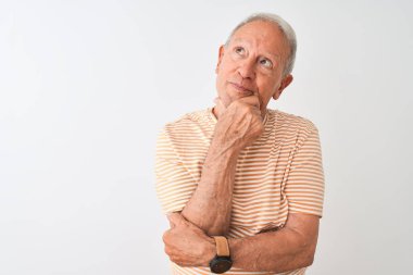 Üst düzey gri saçlı adam çizgili t-shirt izole beyaz arka plan üzerinde duran giyen bir soru hakkında endişeli düşünme, endişeli ve çene üzerinde el ile sinir