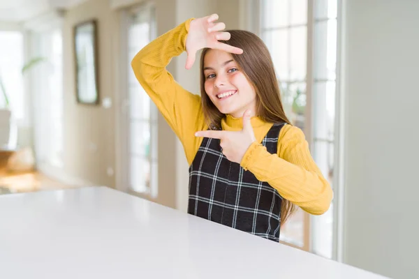 Hermosa Niña Joven Sentada Mesa Sonriendo Haciendo Marco Con Las —  Fotos de Stock