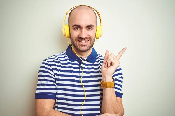 Joven Escuchando Música Con Auriculares Amarillos Sobre Fondo Aislado Con — Foto de Stock