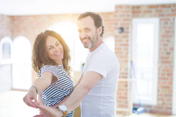 Couple de personnes âgées d'âge moyen déménageant dans une nouvelle maison, danser et smil — Photo