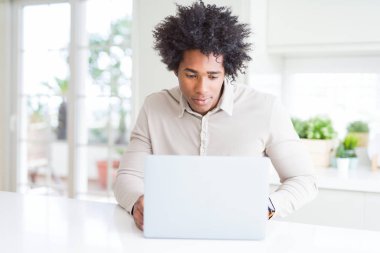African American man working using laptop with a confident expression on smart face thinking serious clipart