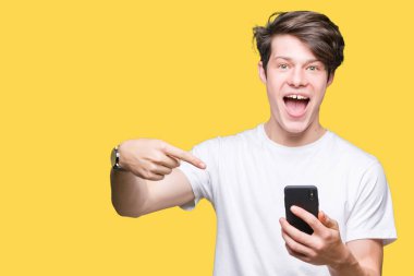 Genç adam izole arka el ve parmak ile işaret çok mutlu üzerinde akıllı telefon kullanma