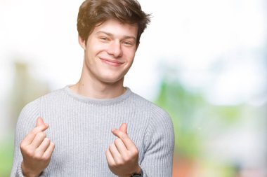 Maaş ödeme için milyoner iş soran izole arka plan yapıyor para hareketi el ile üzerinden kış kazak giyen genç yakışıklı adam