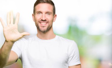 Yakışıklı adam gösterilen ve parmakları ile işaret casual beyaz t-shirt giyen beş kendinden emin ve mutlu gülümseyerek iken numara.