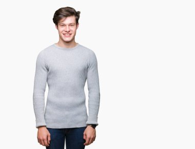 Yüzünde mutlu ve güzel bir gülümseme ile izole arka plan üzerinde kış kazak giyen genç yakışıklı adam. Şanslı kişi.