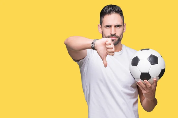 若い男の怒った顔 ダウン親指で嫌悪感を示すマイナス記号 拒絶反応の概念と分離された背景にサッカー サッカー ボールを保持 — ストック写真