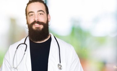 Doktor tıbbi ceket ve mutlu ve güzel bir gülümseme ile stetoskop yüzünde giymiş uzun saçlı. Şanslı kişi.