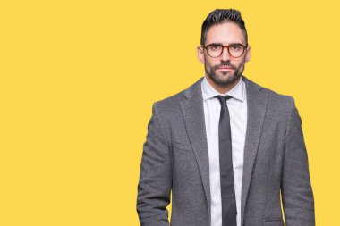 Genç yakışıklı iş adamı izole arka plan gevşek yüzünde ciddi bir ifade ile üzerinden. Basit ve doğal kameraya bakıyor.