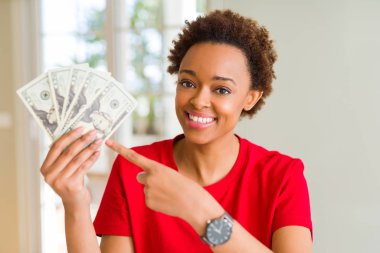 Yirmi dolar banka banknotları tutan genç Afrikalı Amerikalı kadın el ve parmak ile işaret çok mutlu