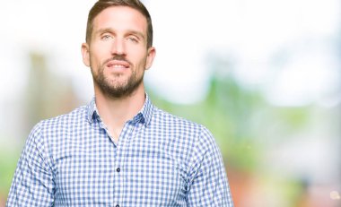 Yakışıklı iş adamı ile mavi gözlü el ele tutusun ve rahat ve neşeli gülümseyen parmak çarpı işareti. Başarı ve iyimser