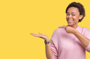 Güzel genç Afro-Amerikan kadın üzerinden hayran ve el ile sunulması ve parmak ile işaret ederken kameraya gülümseyen izole arka plan.