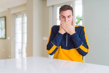 Evde yakışıklı adam yanlışlık için eller ile ağız kapsayan şok. Gizli konsept.