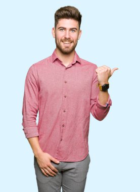 Genç yakışıklı iş casual adam arıyor ve başparmak yanında yukarıyı mutlu yüz ile gülümseyen.