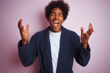 Genç afro-amerikan adam pijama giyen izole pembe arka plan üzerinde ayakta deli ve heyecan çığlık kapalı gözleri ile başarı için deli ve deli kutluyor. Kazanan kavramı