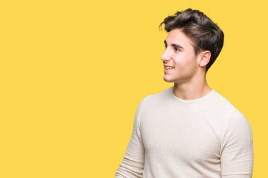 Yakışıklı delikanlı uzak tarafına yüzünde, doğal ifade gülümseme ile seyir izole arka plan üzerinde. Kendine güvenen gülüyor.