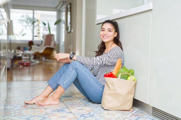 Jonge Vrouw Zittend Keukenvloer Met Een Papieren Zak Vol Verse — Stockfoto