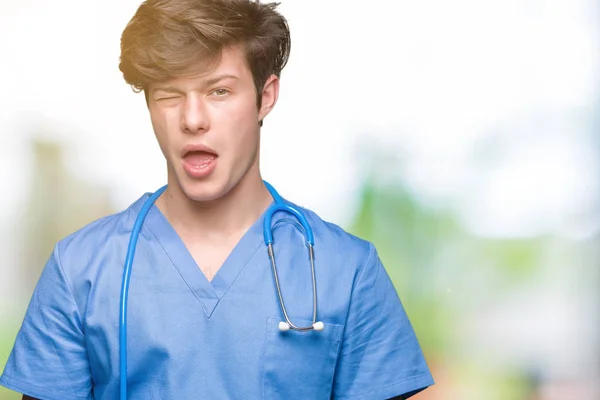 Unga Läkare Bär Medicinsk Uniform Över Isolerade Bakgrund Winking Tittar — Stockfoto