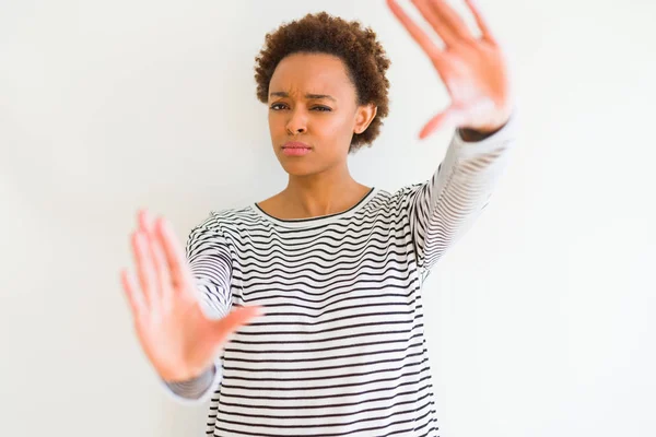 手のひらと指を使ってフレームを笑う白い背景の上にストライプセーターを着た若い美しいアフリカ系アメリカ人女性 カメラの視点 — ストック写真