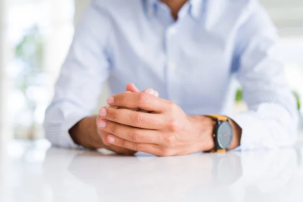 Primer plano del hombre con las manos cruzadas sobre la mesa blanca — Foto de Stock